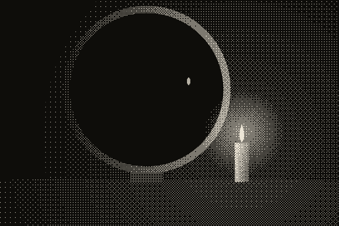 a round black mirror lit by a candle